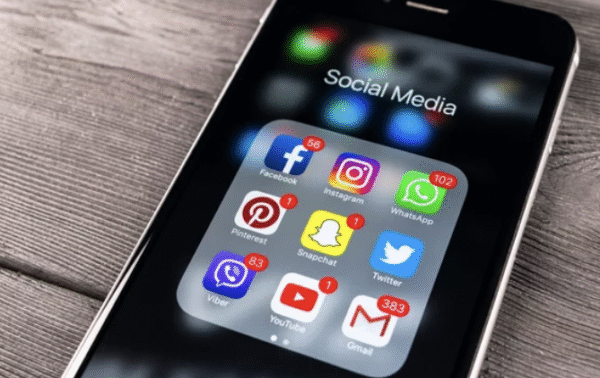 Smartphone screen showing social media apps like Facebook, Instagram, WhatsApp, and YouTube